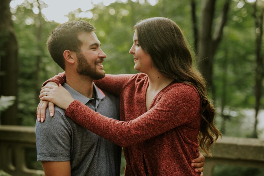 woman in red shirt hugs bearded man during their IMA engagement session