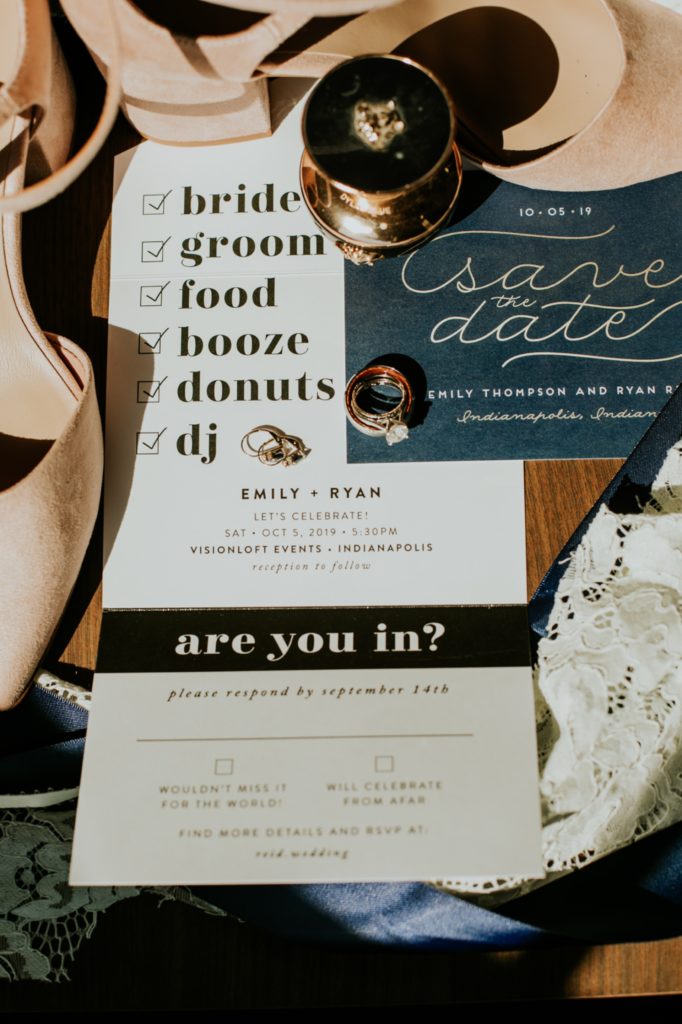 wedding invitations with food, booze, and donuts at blumlux building in window light