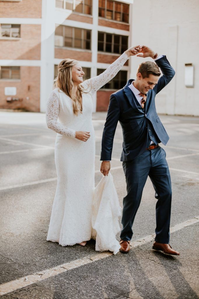 bride twirls groom in the crackers parking lot before their VisionLoft Wedding
