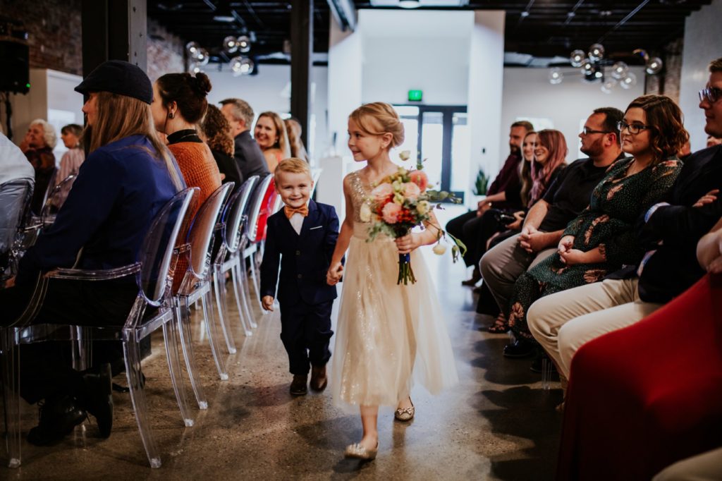 flower girl and ring bearer walk down the aisle for a VisionLoft Wedding