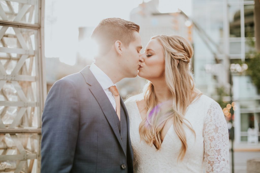 bride and groom kiss at sunset in downtown indianapolis on the day of their VisionLoft Wedding
