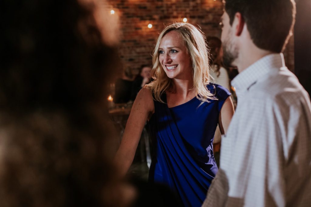 blonde woman in blue dress smiles and dances at a VisionLoft Wedding