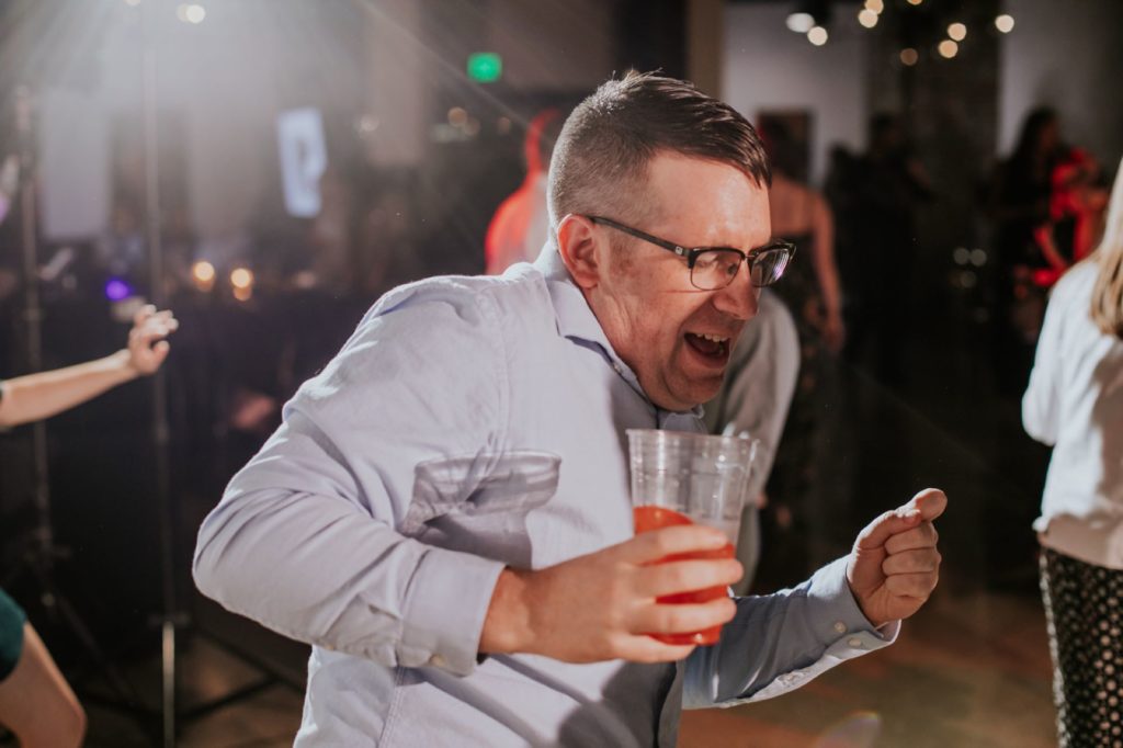 man dances with a beer in hand at a wedding in downtown indy