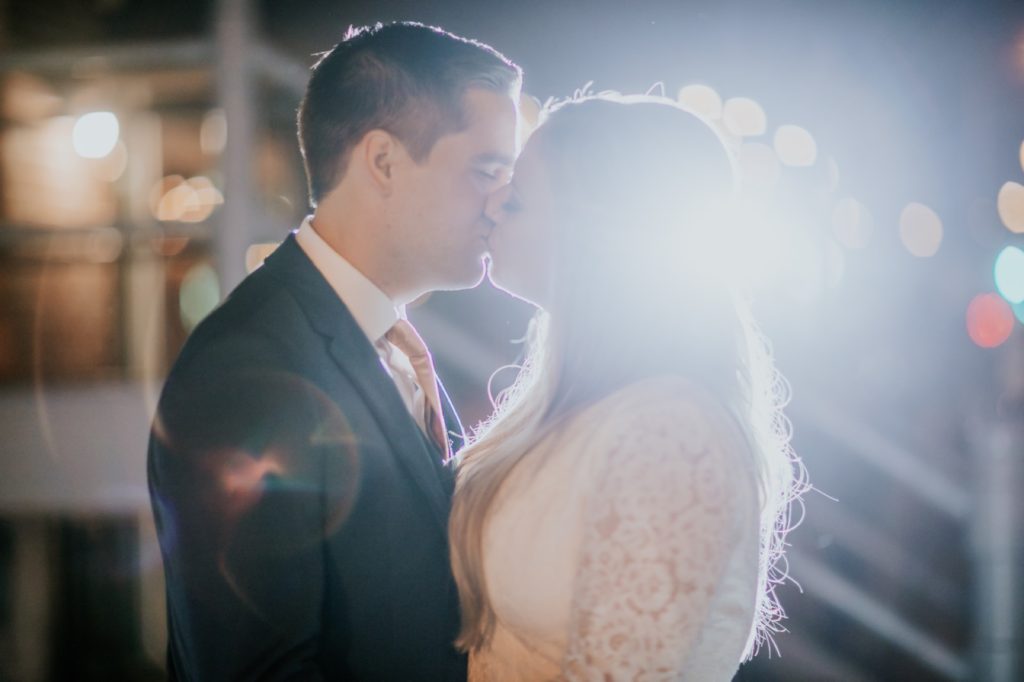 bride and groom kiss at night on their VisionLoft Wedding day