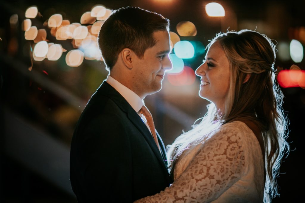 bride and groom look deep into each other's eyes in front of bokeh on their VisionLoft Wedding day