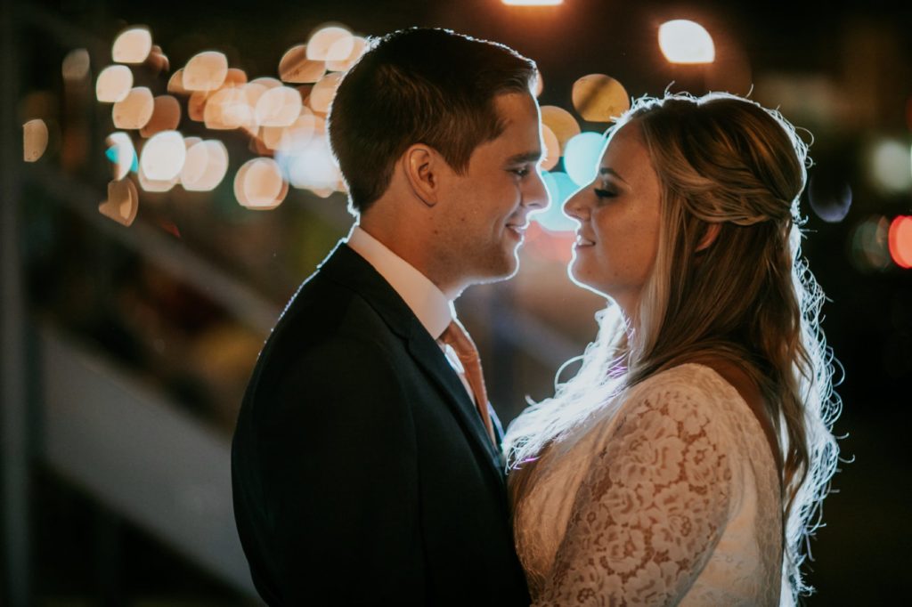 bride and groom prepare to kiss in front of bokeh on their VisionLoft Wedding night
