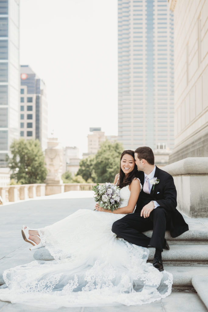 bride and groom sitting on the Indiana War Memorial before their Indiana Roof Ballroom wedding
