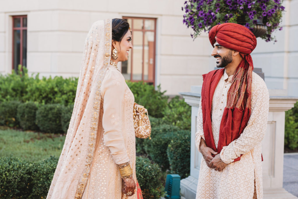 groom in red turban sees bride for first time on wedding day at their Coxhall Gardens wedding