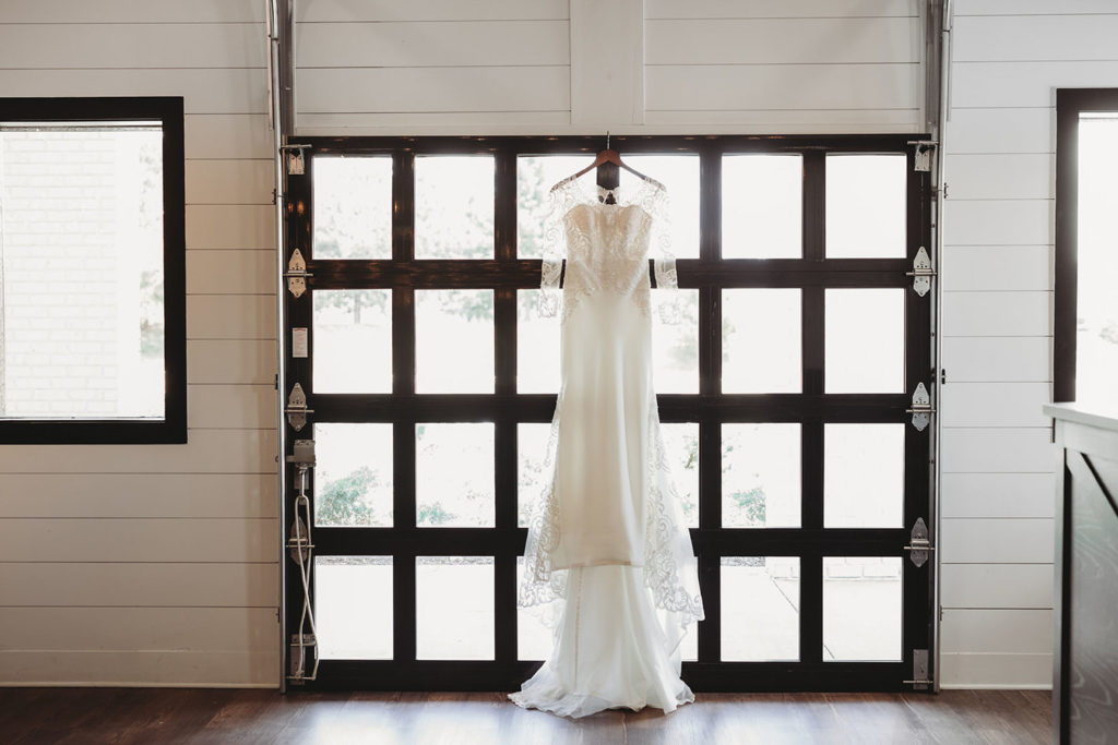 wedding dress hangs in garage door window in Carmel Indiana