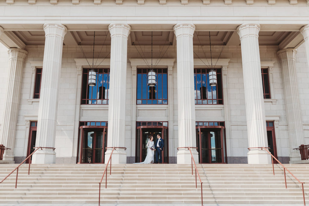 bride and groom stand on top of stairs at the Palladium