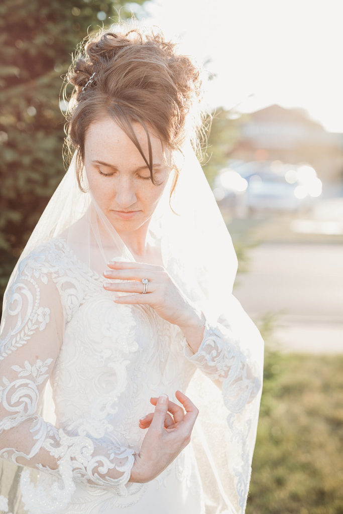 bride adjusts veil during golden hour at a Bash wedding