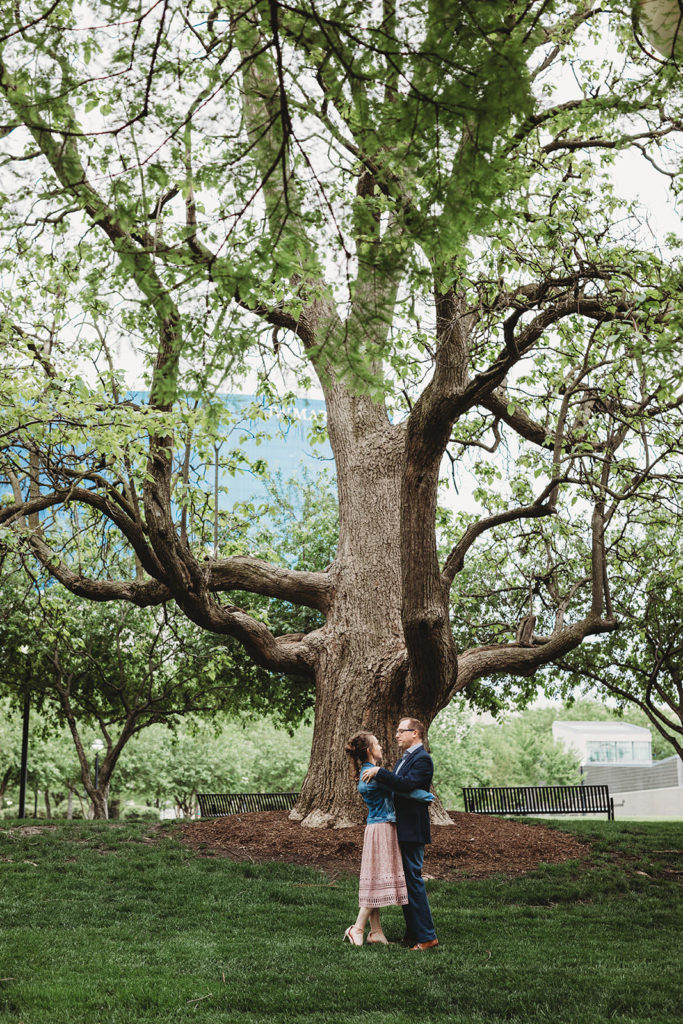 man and woman dance in front of old tree during white river park engagement session