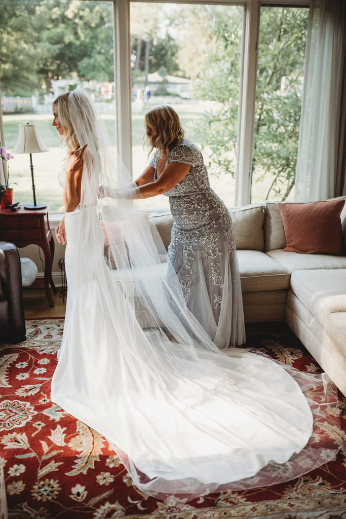 bride helped into dress by mother during her indianapolis elopement