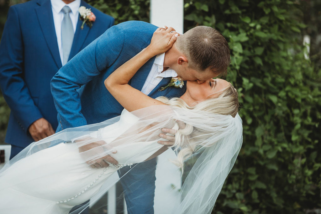 groom dips and kisses bride for first kiss during their indianapolis elopement