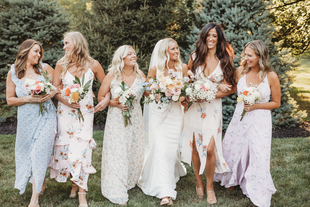 bride and bridesmaids walking in backyard during their indianapolis elopement