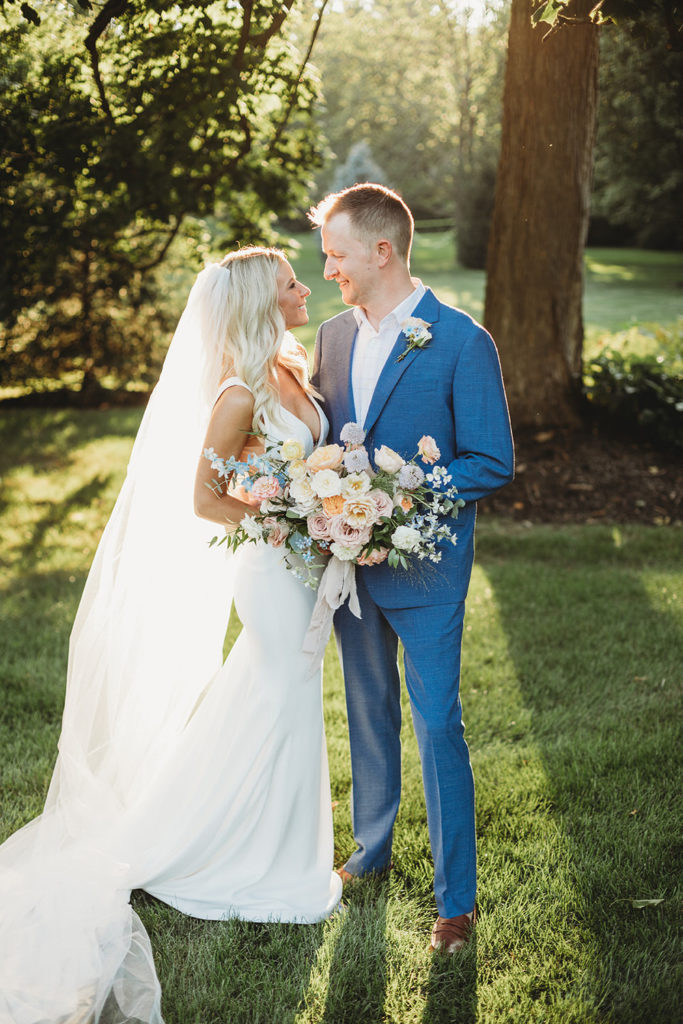 blonde bride and groom in blue suit look at each other at sunset during their indianapolis elopement