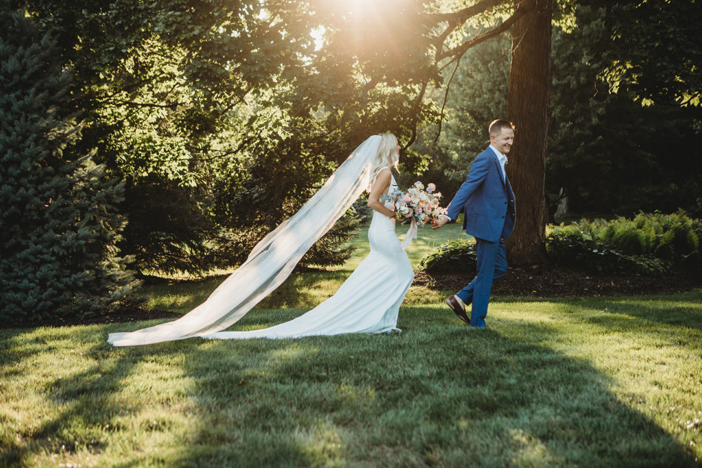 groom leads bride by the hand at sunset during their indianapolis elopement