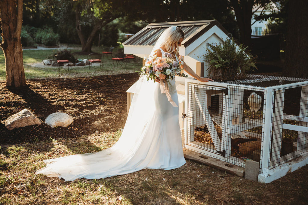 blonde bride stands next to chicken coop in carmel indiana