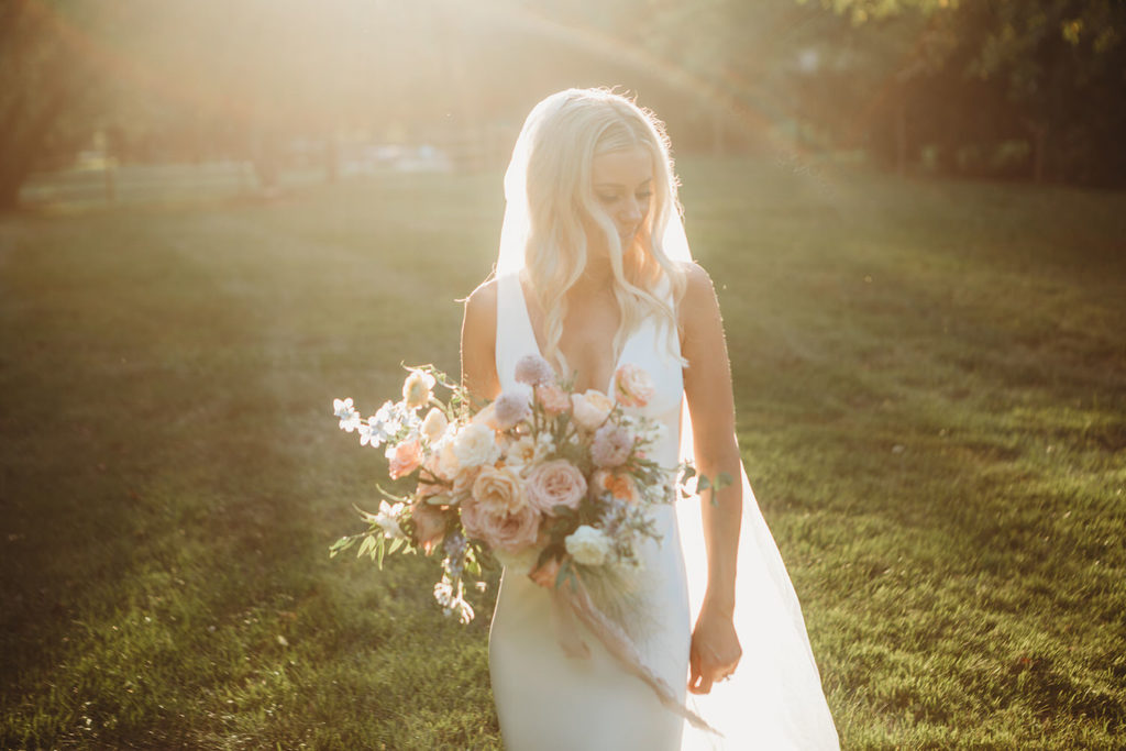 blonde bride holding flowers at sunset during her indianapolis elopement