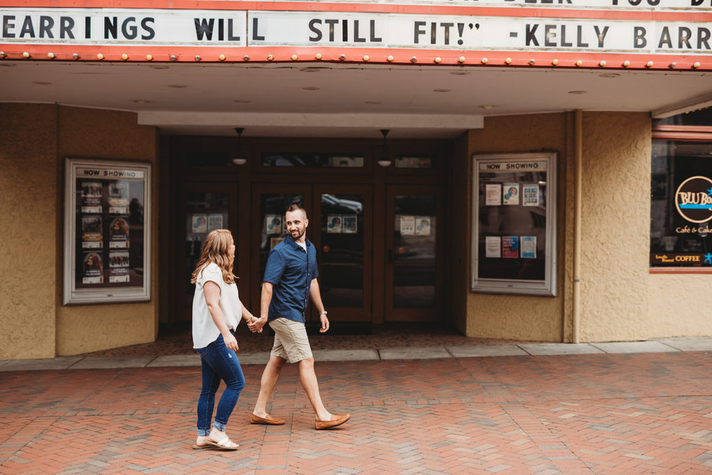 Couple hold hands and walk under marquee for buskirk-chumley theater