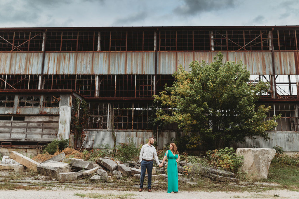 man and woman hold hands in front of one world at woolery mill