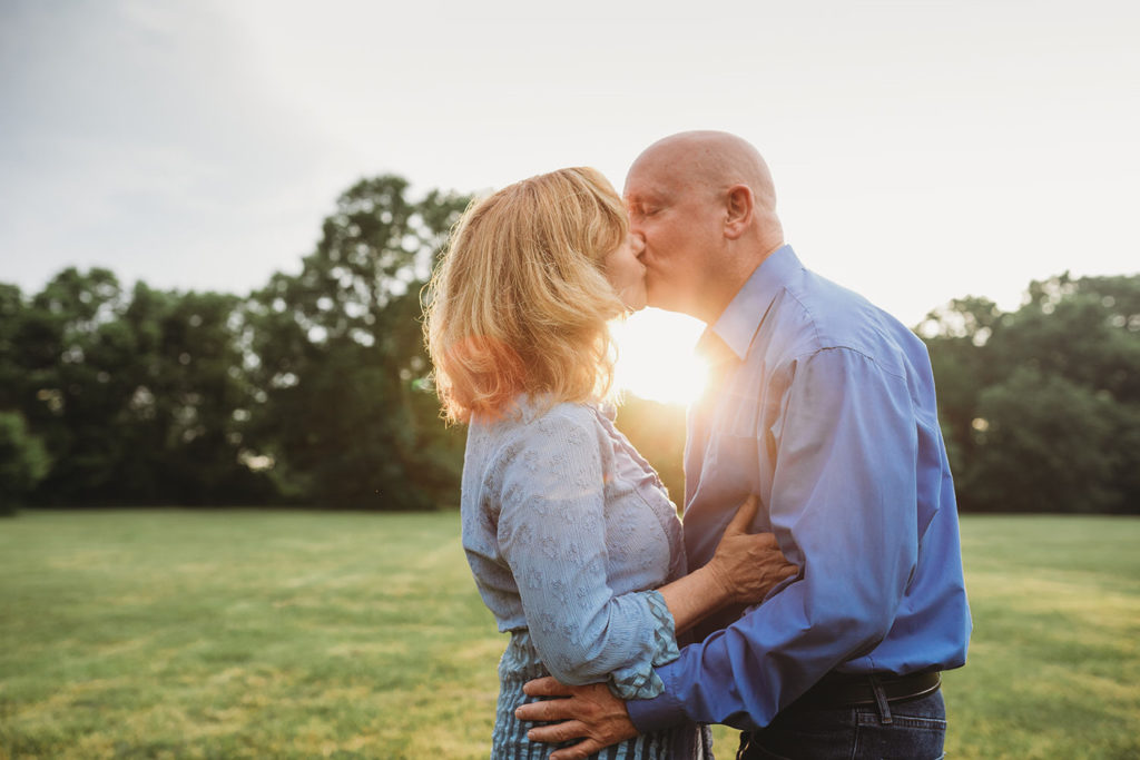 man and woman kiss at sunset during their hamilton county park engagement session
