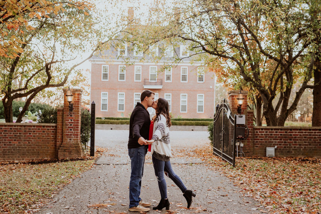 man and woman kiss in front of coxhall mansion at their coxhall gardens engagement session