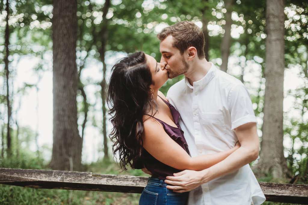 Young Couple kissing in the woods during their Eagle Creek Reservoir Engagement