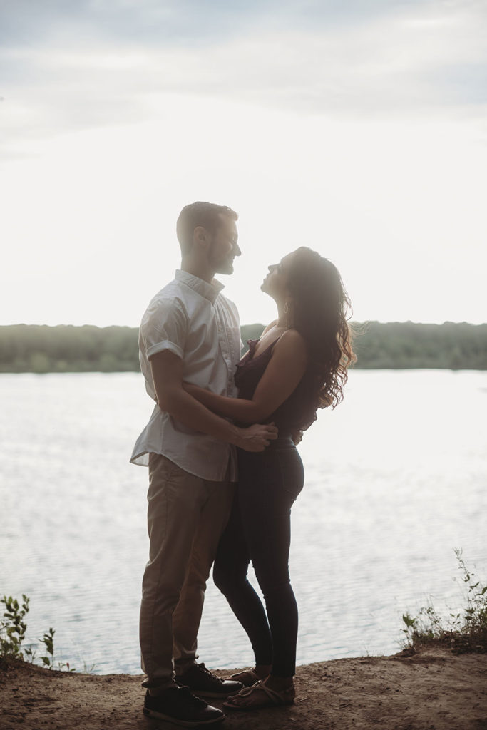 silhouette of couple looking at each other in front of Eagle Creek Reservoir during their Engagement shoot