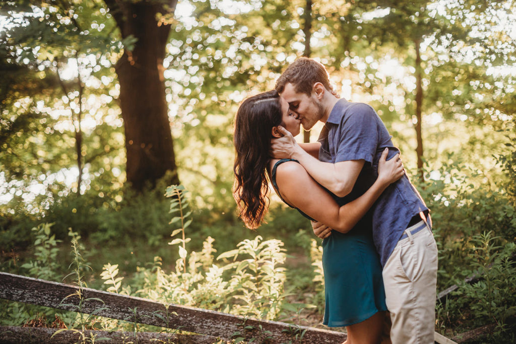 young couple kissing in woods at sunset at an indianapolis park