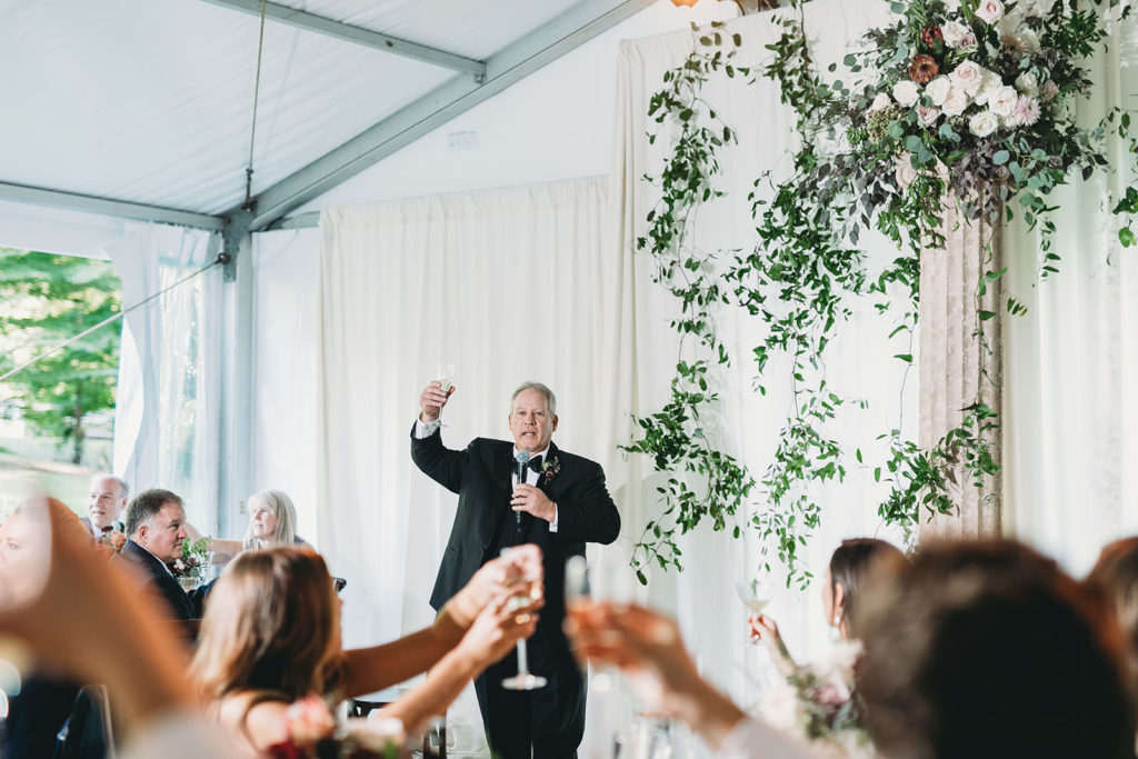 father of bride raises glass after giving a toast