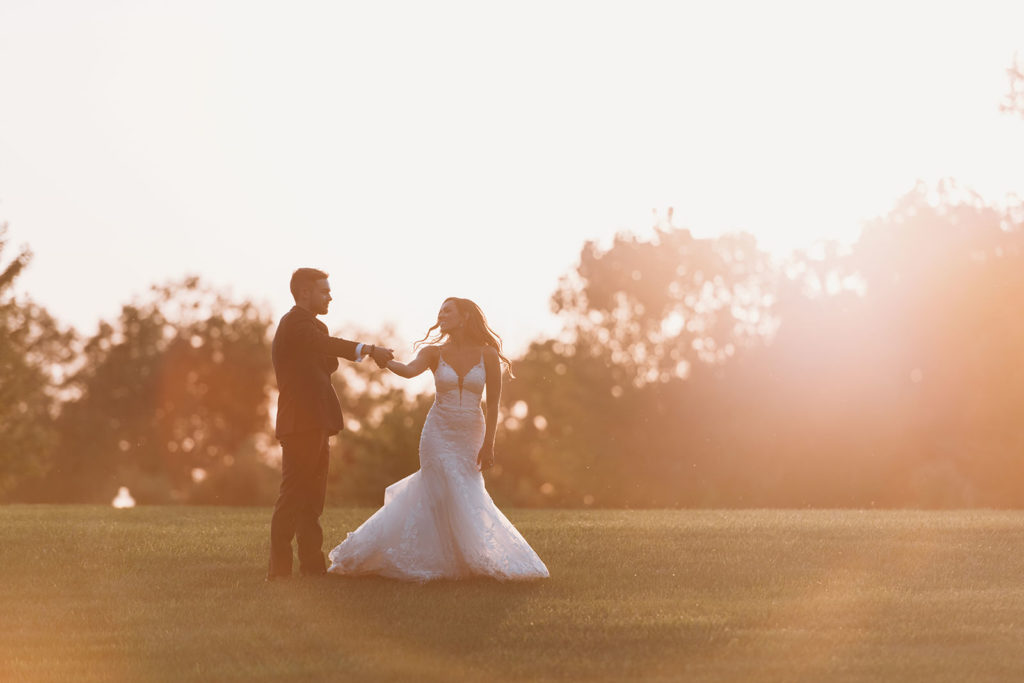bride and groom dance in an open field at sunset during their Carmel Backyard Wedding