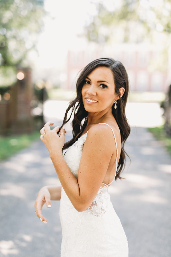 gorgeous bride plays with her brown hair at coxhall gardens before her carmel backyard wedding