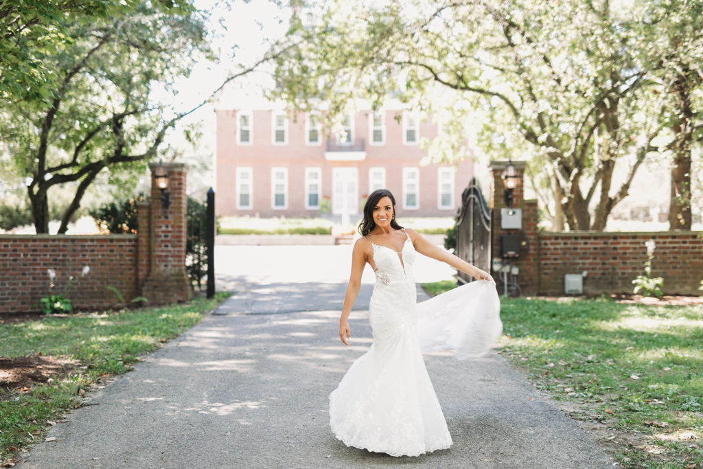 bride spinning with wedding dress in front of Coxhall Mansion before her carmel backyard wedding