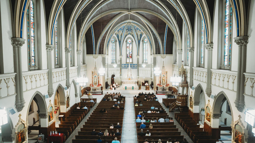 wide shot from back of St. John the Evangelist Catholic Church from balcony during a wedding ceremony
