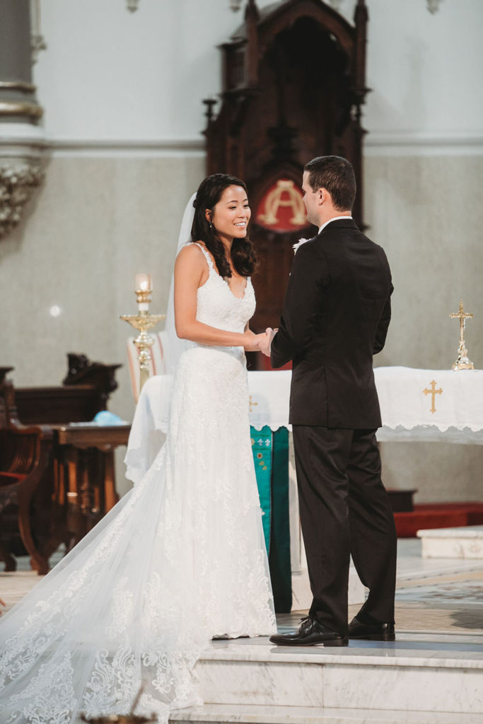 bride and groom look at each other with love during their wedding at St. John the Evangelist Catholic Church 