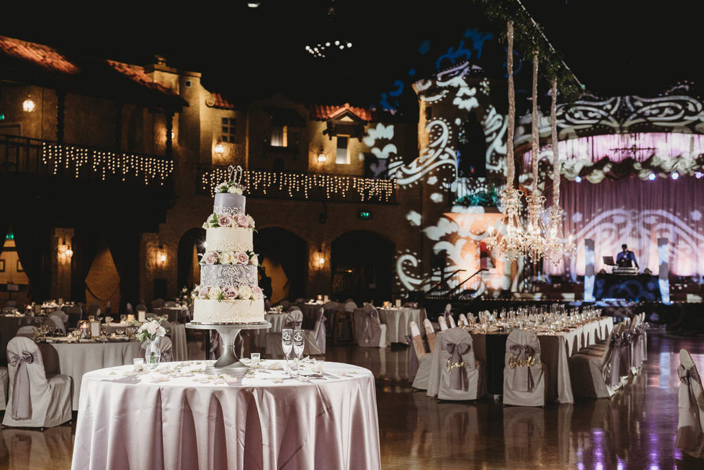 wide shot of Indiana Roof Ballroom wedding with wedding cake and long table for wedding party with hanging floral