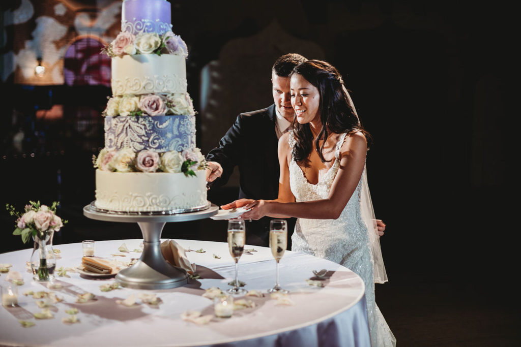 bride and groom cut a 4 tiered cake at an Indiana Roof Ballroom wedding