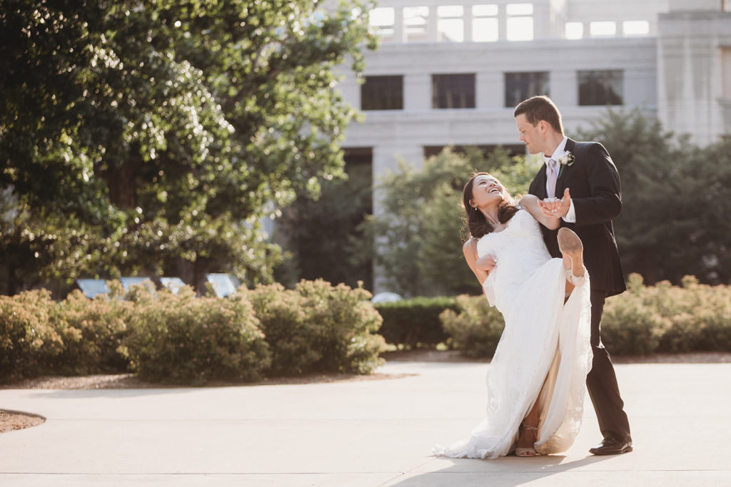newly weds dance outside indiana statehouse and groom dips bride during break from their Indiana Roof Ballroom wedding