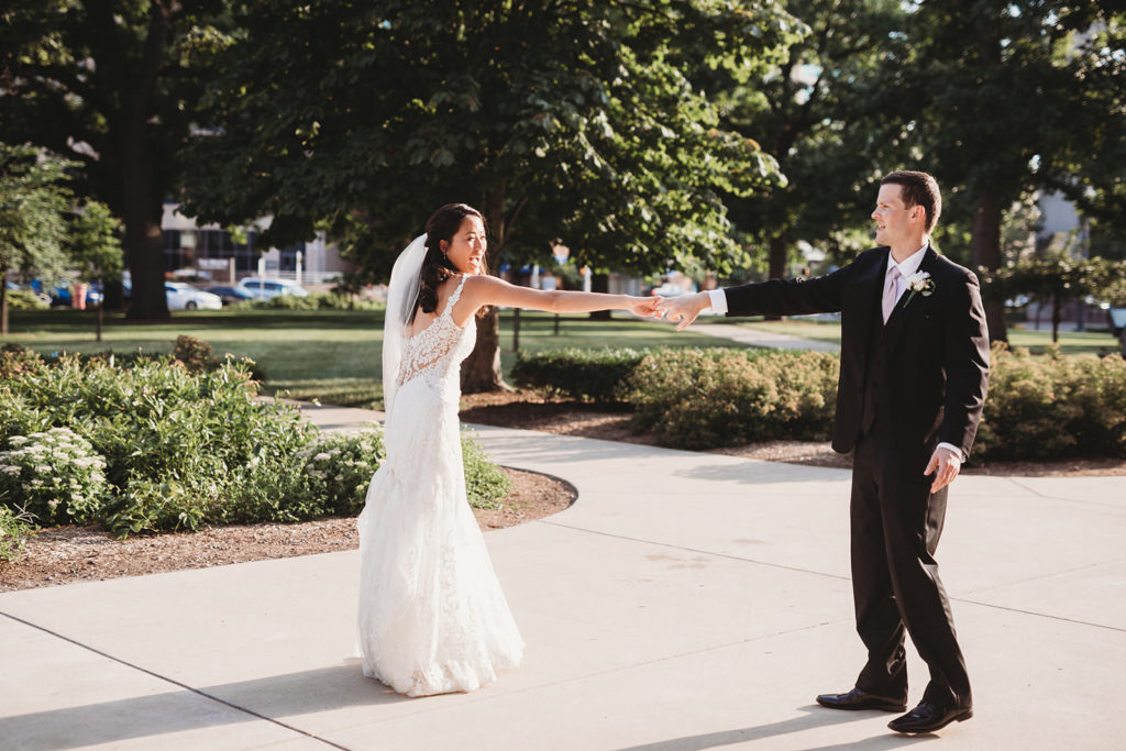 bride and groom dance outside indiana statehouse during portraits for their Indiana Roof Ballroom wedding