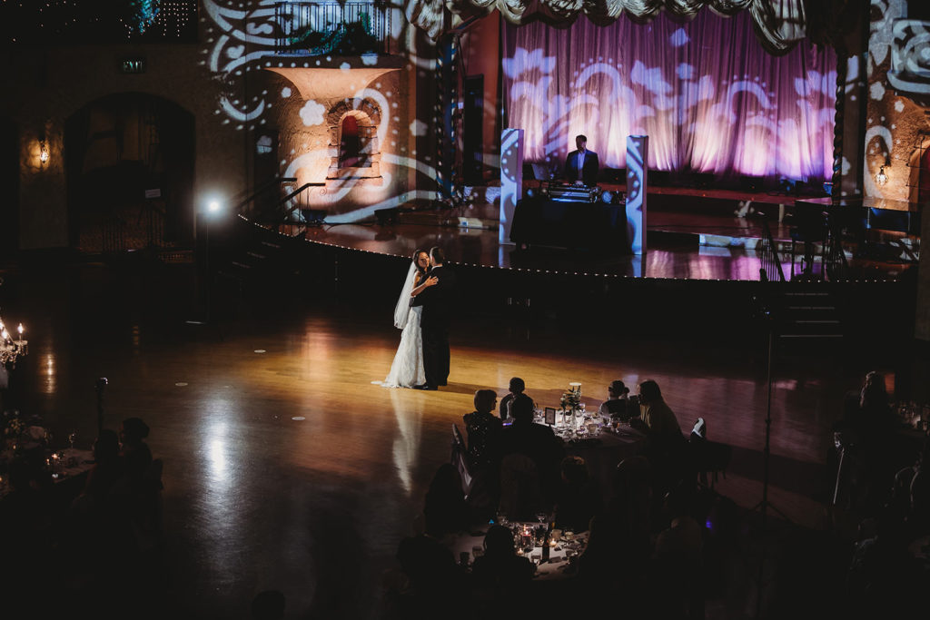wide shot of Indiana Roof Ballroom wedding during bride and groom's first dance where they're lit by a spotlight