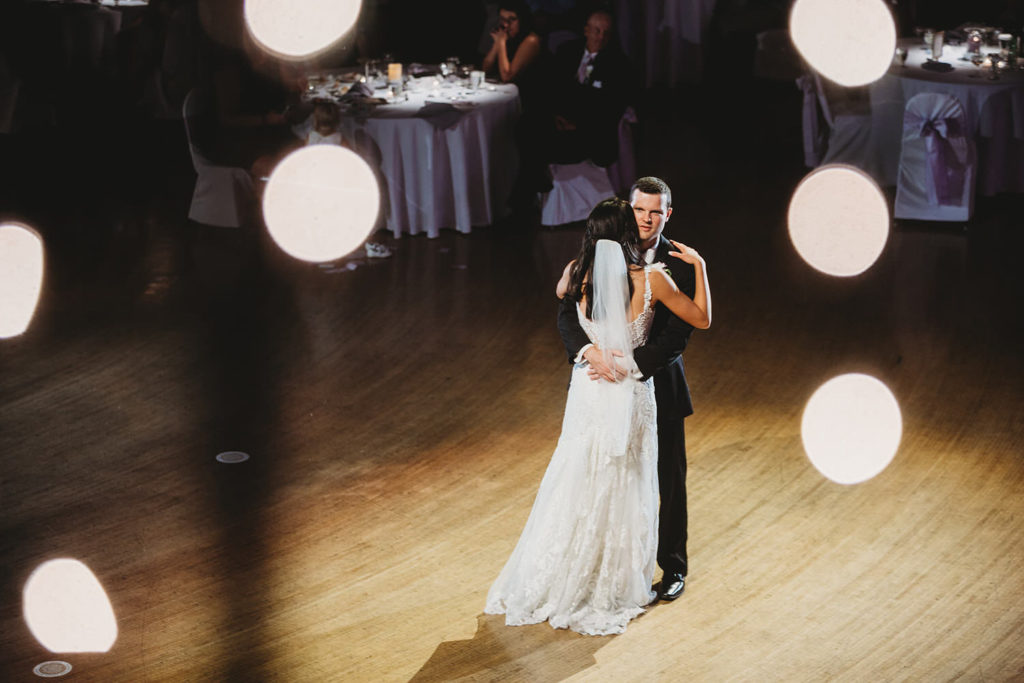 bokeh frames the bride and groom as they share their first dance during their Indiana Roof Ballroom wedding