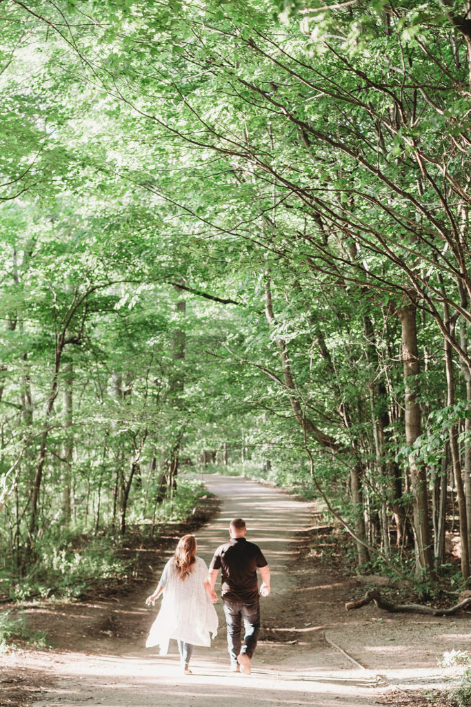 Couple walk through trees during their Indy Reservoir Engagement