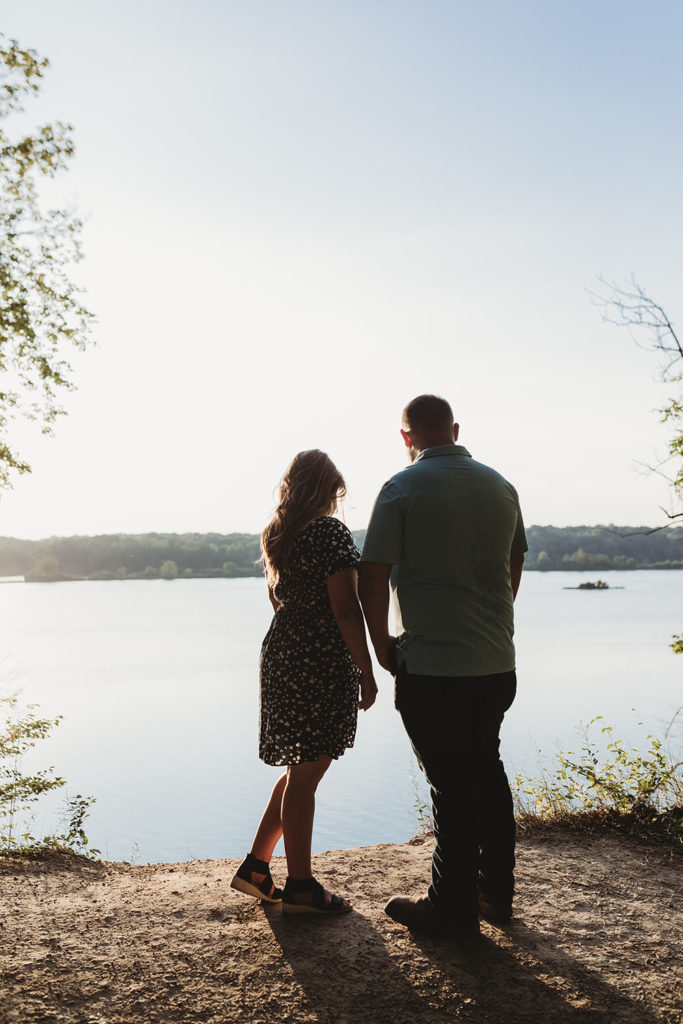 silhouettes of two people standing on a bluff looking out at the reservoir during their Indy Reservoir Engagement