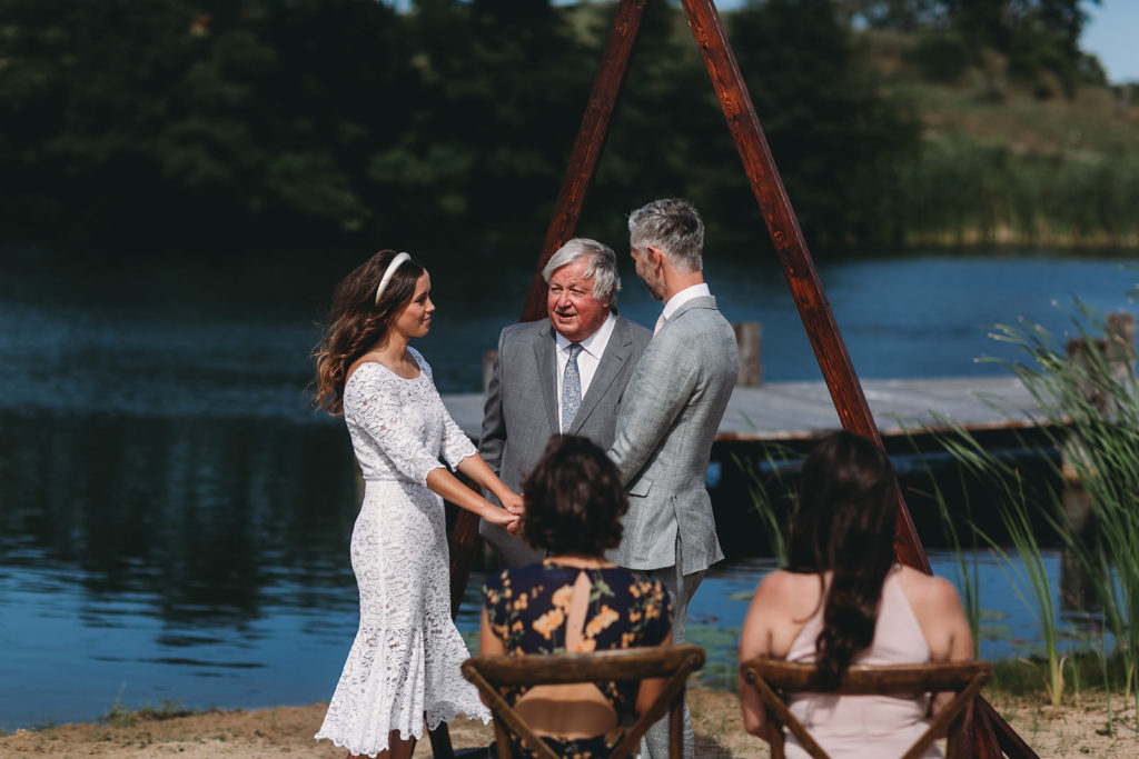 older man marries young bride and groom on beach at their traders point creamery wedding