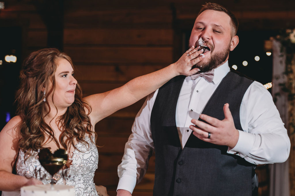 bride smears cake on groom's face