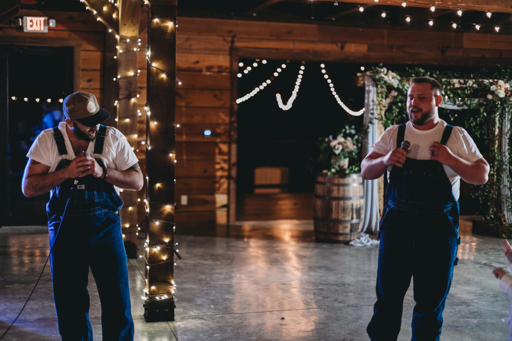 groom and best man in overalls singing at a 3 Fat Labs wedding