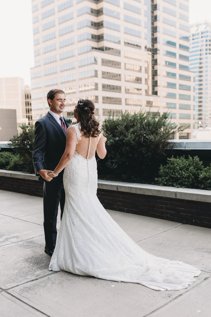 bride and groom's first look on top of regions tower during their wedding celebration