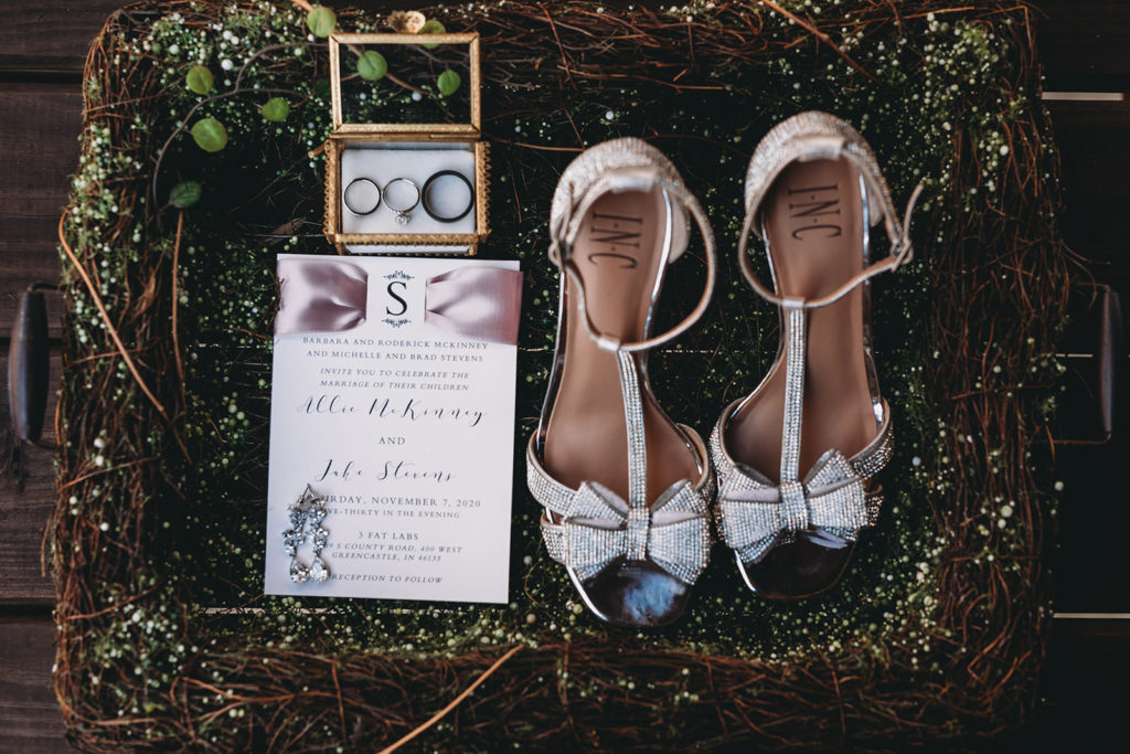 shoes, rings, and paper in a floral basket at a 3 Fat Labs wedding