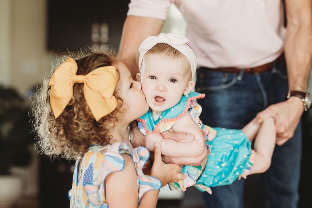 toddler kisses her baby sister in this parker city family portrait